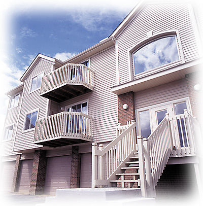 Multi-story home finished in vinyl siding with balconies and brick accents